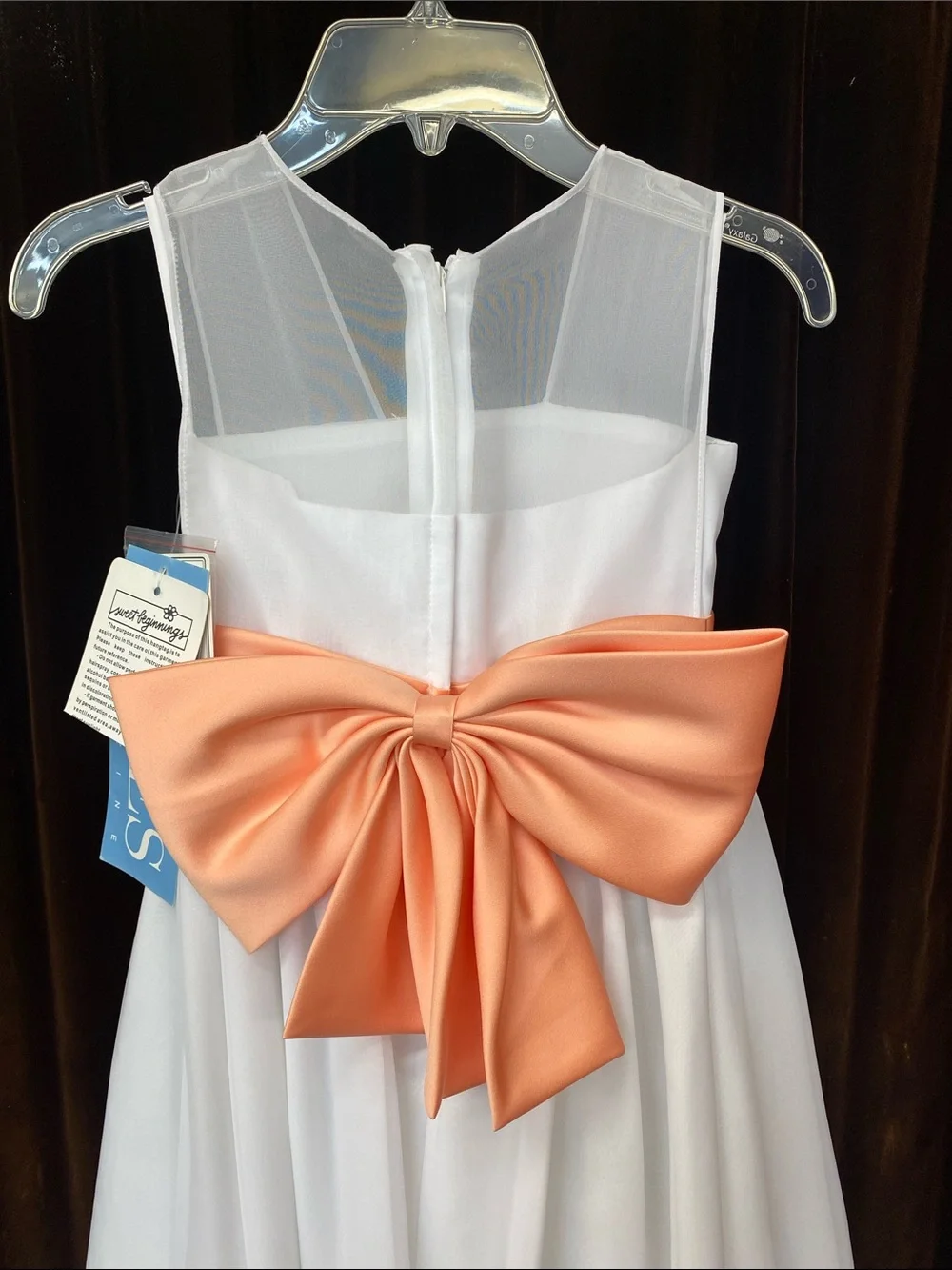 White Girls' Sleeveless Dress with Coral Sash and Floral Accent